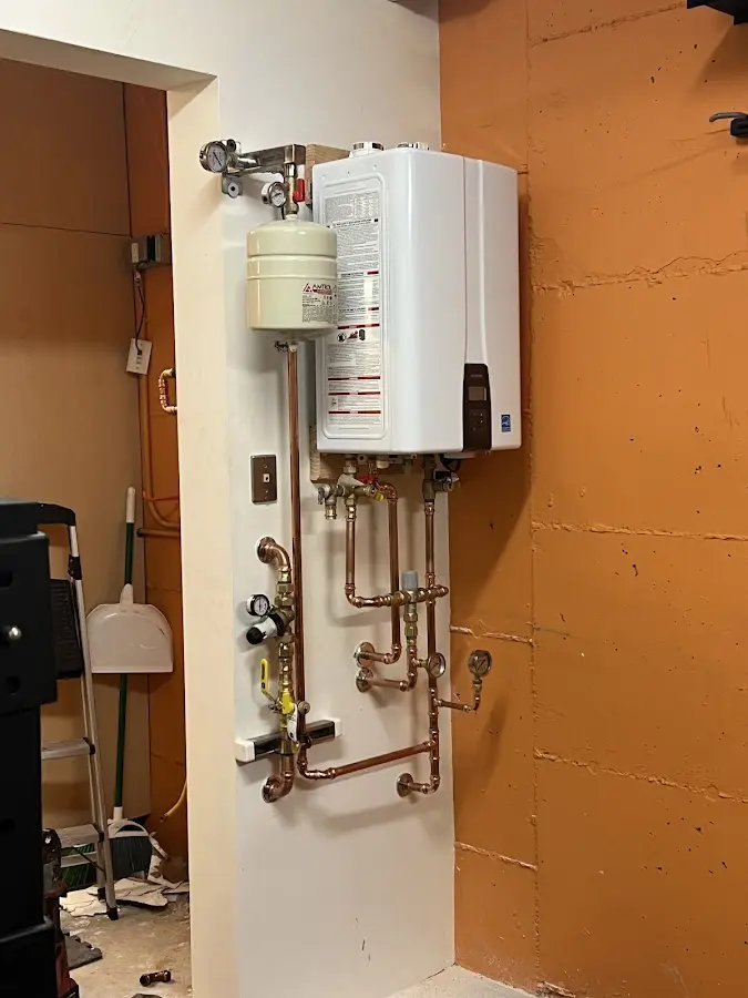 Plumbing technician inspecting water heater connections in Hermosa Beach